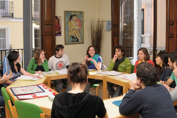 Round table young foreign boys learning Spanish