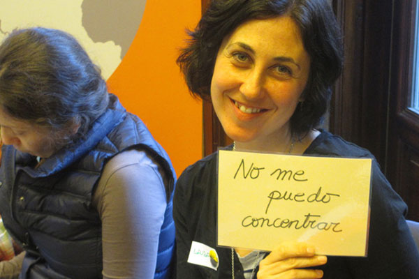 Young foreign girl shows a paper with a phrase in Spanish